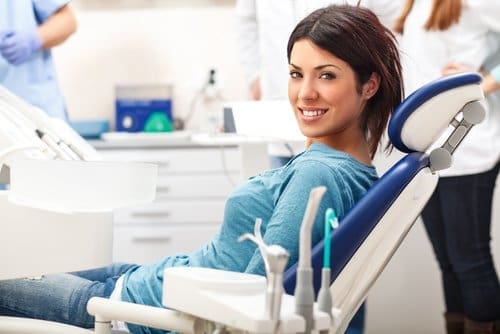 Woman leaning back in dental chair and smiling