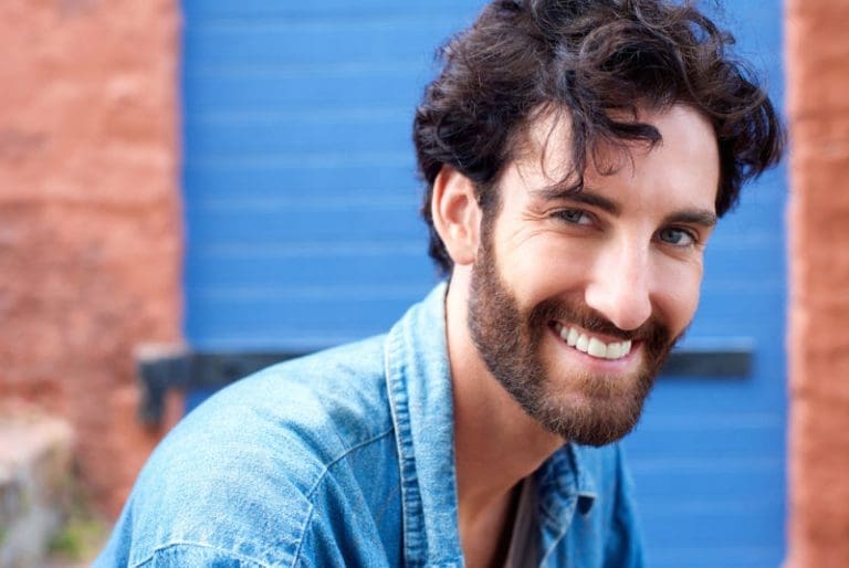 Man in denim jacket smiling after teeth whitening in Lexington