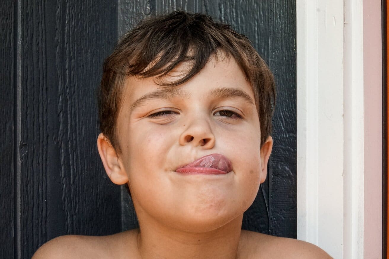 Child stretching out their tongue toward their nose