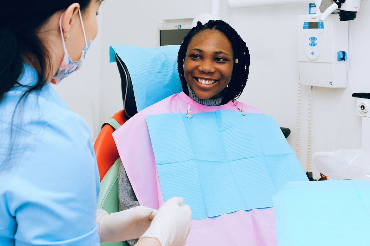 Woman in dental chair smiling at her dentist