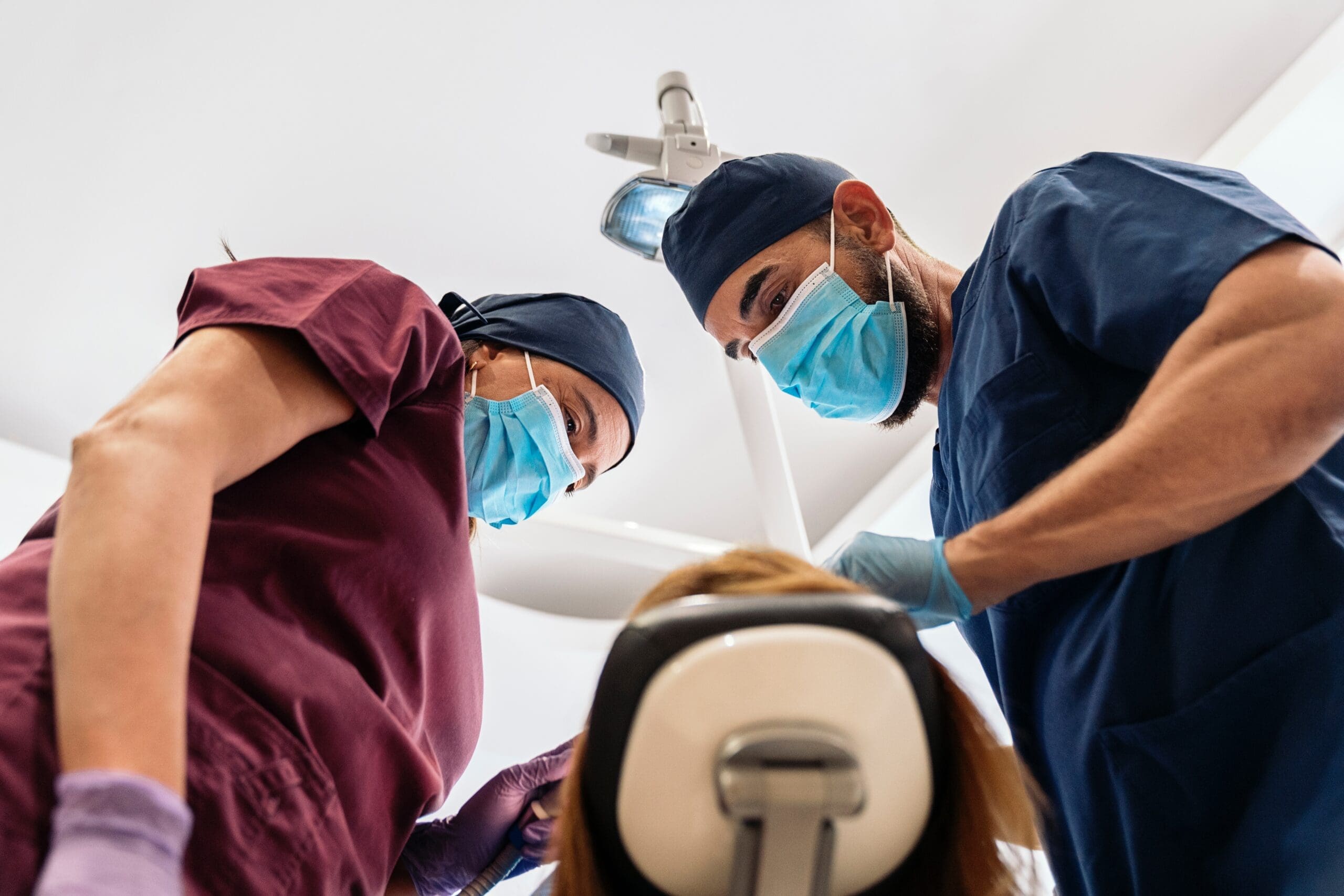 Dentist and assistant performing a laser lip and tongue tie treatment on an adult in Lexington