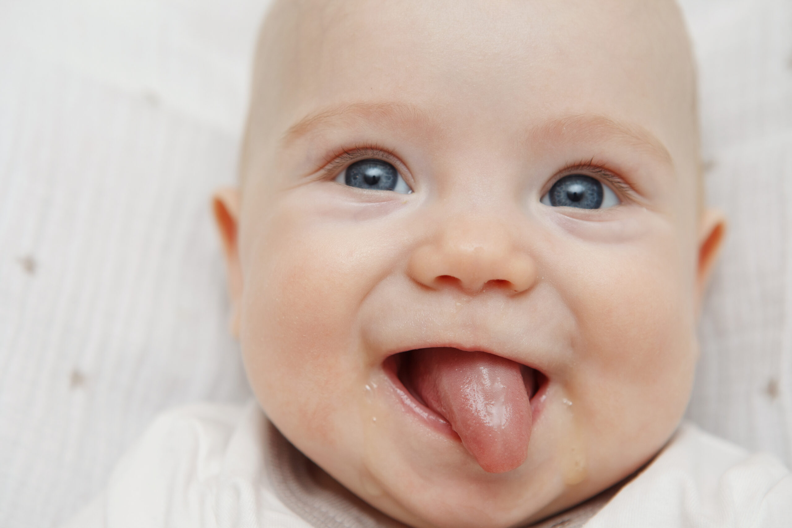 Close-up of happy baby sticking their tongue out