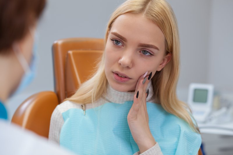 A beautiful woman with a toothache talking to her dentist