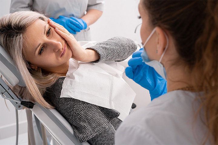 Woman experiencing dental emergency in Lexington