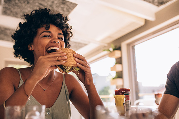 Lexington patient eating burger while on Invisalign treatment