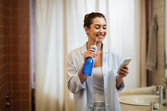 Lexington patient using water flosser during Invisalign treatment