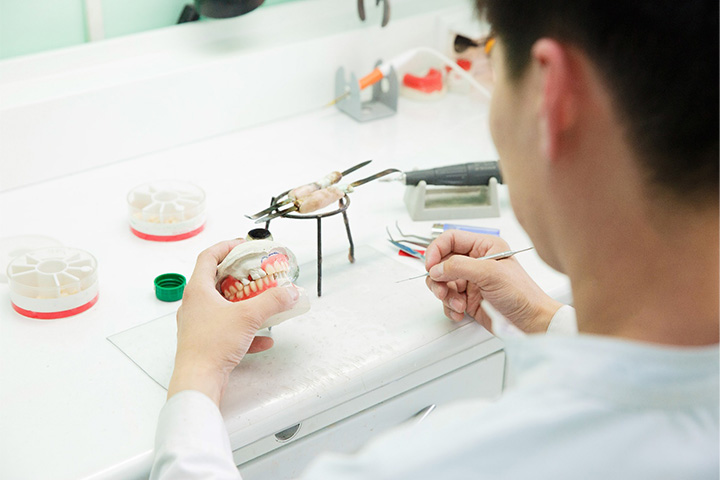 A dental technician crafting dentures.