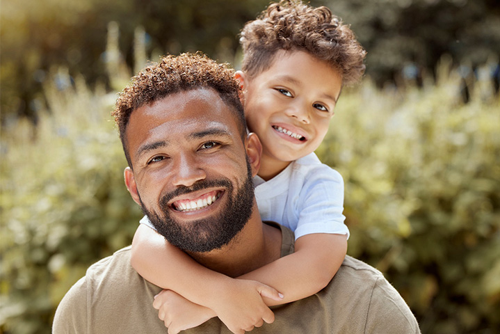 Father enjoying a healthier smile while smiling with his son.
