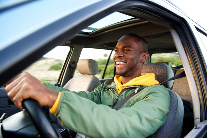 Man smiles while driving.